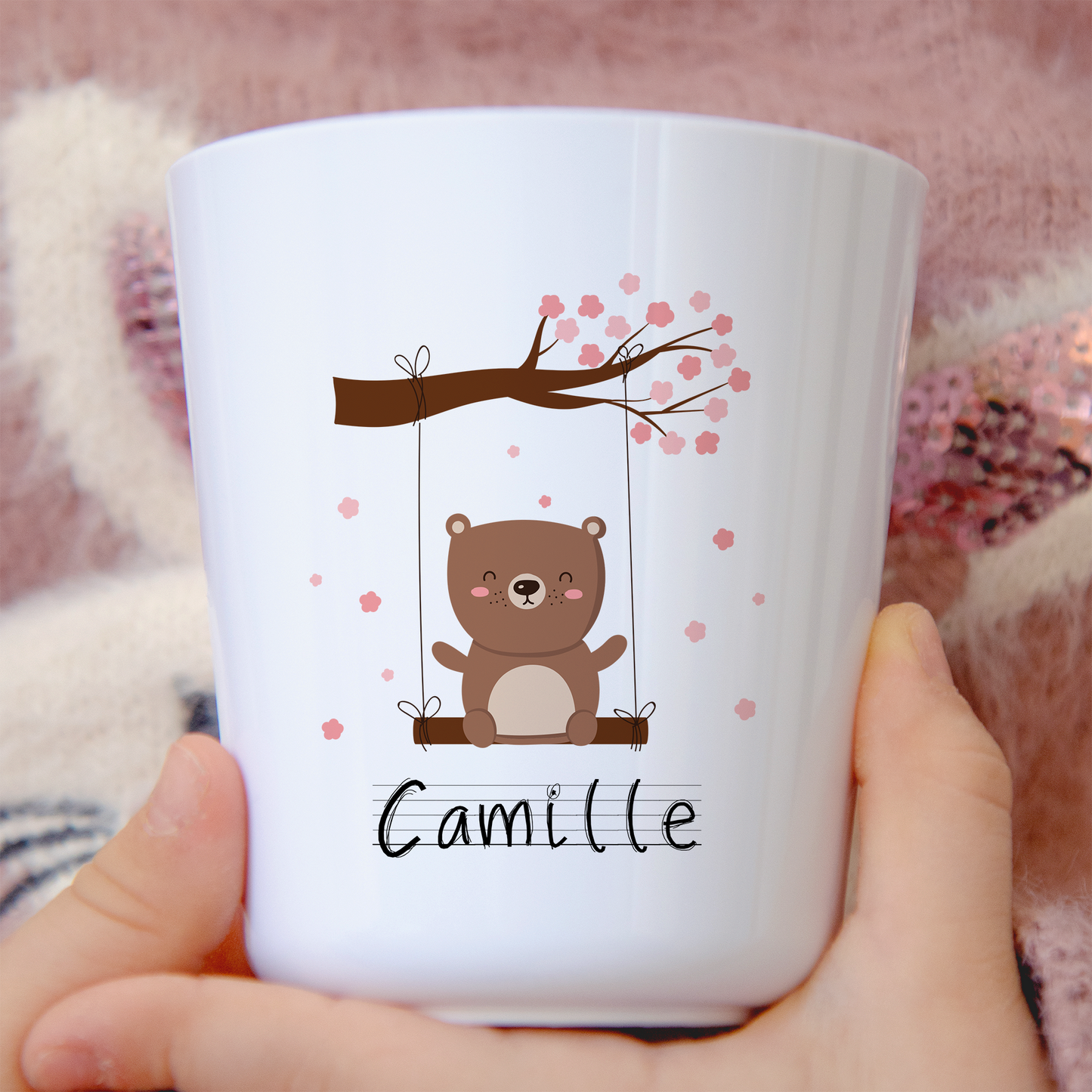 Gobelet en plastique blanc avec un ourson sur une balançoire, personnalisable avec un prénom. Idéal pour les enfants, léger et incassable