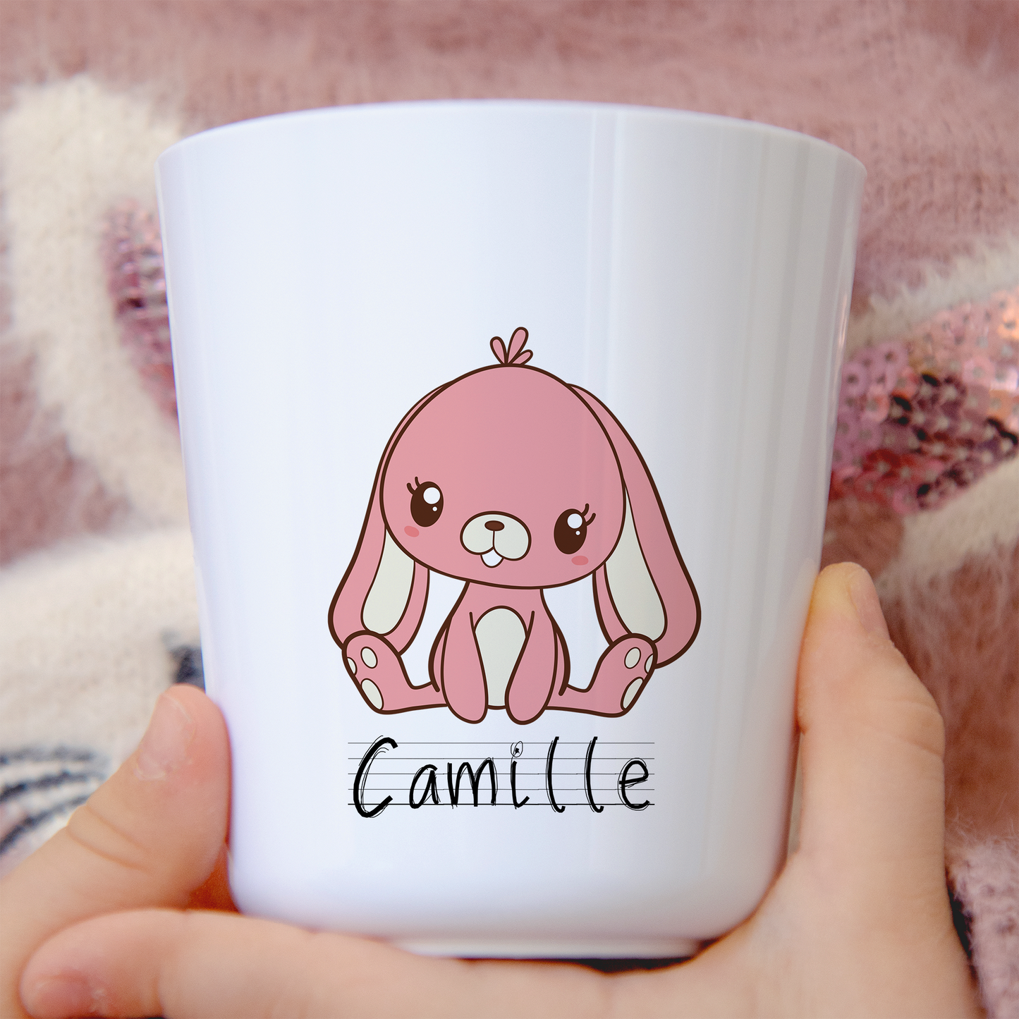 Gobelet en plastique blanc avec un petit lapin rose assis, personnalisable avec un prénom. Idéal pour les enfants, léger et incassable