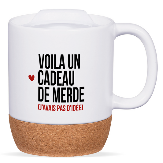 Mug blanc avec base en liège et couvercle en silicone, texte "Voilà un cadeau de merde (j’ai pas d’idée)", personnalisable au verso avec un prénom ou un message.